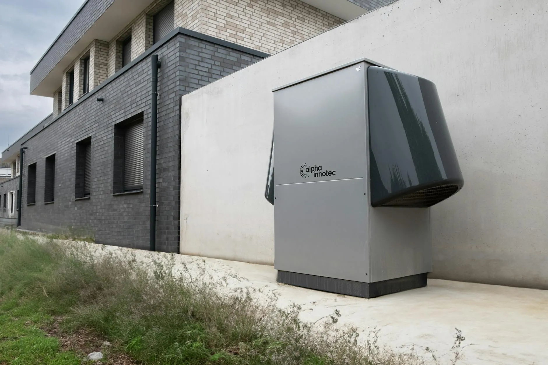 Jednostka zewnetrzna pompy ciepla zamontowana przy domu - profesjonalna instalacja